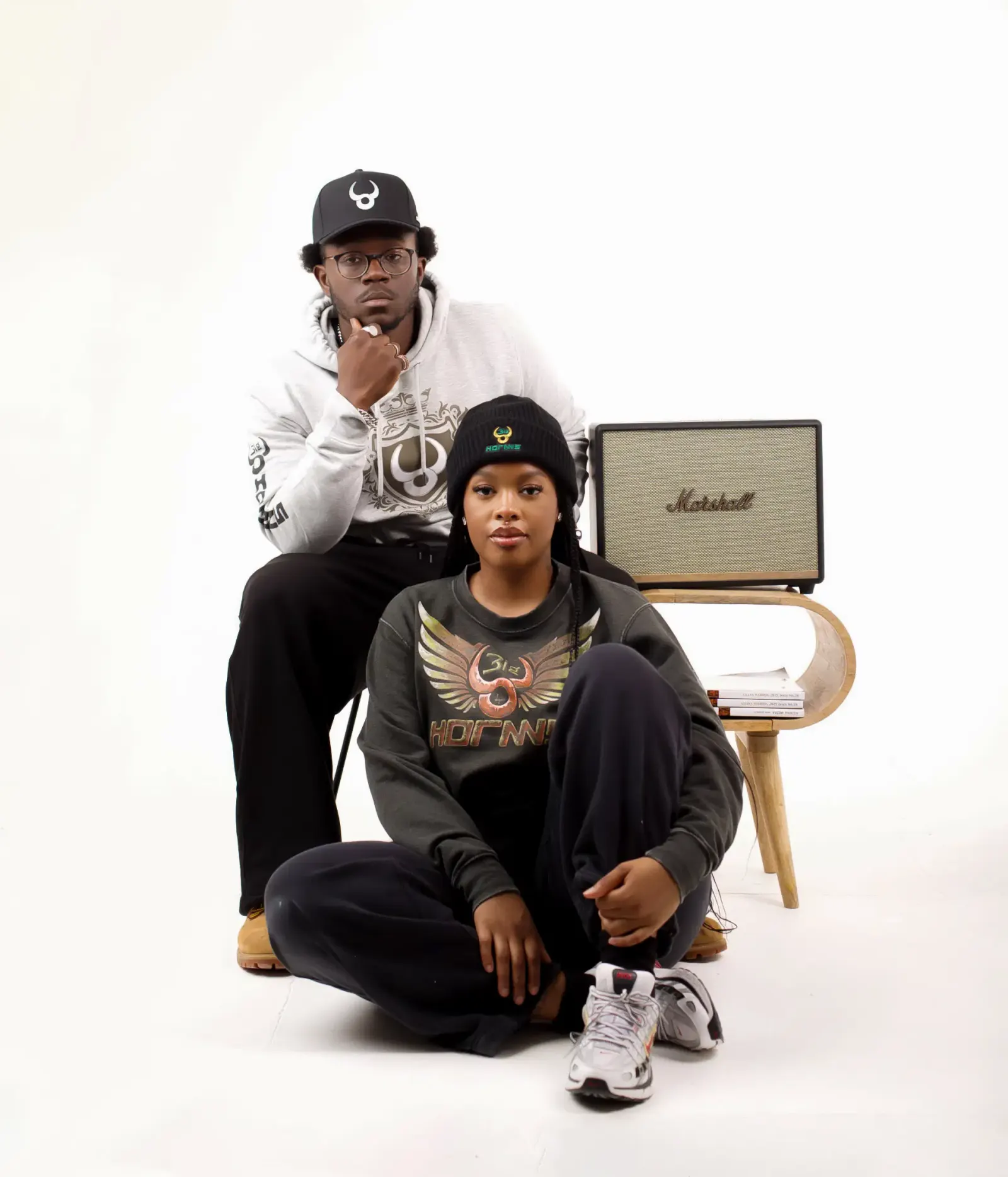 Two people seated in Bighornns hoodies and beanies
