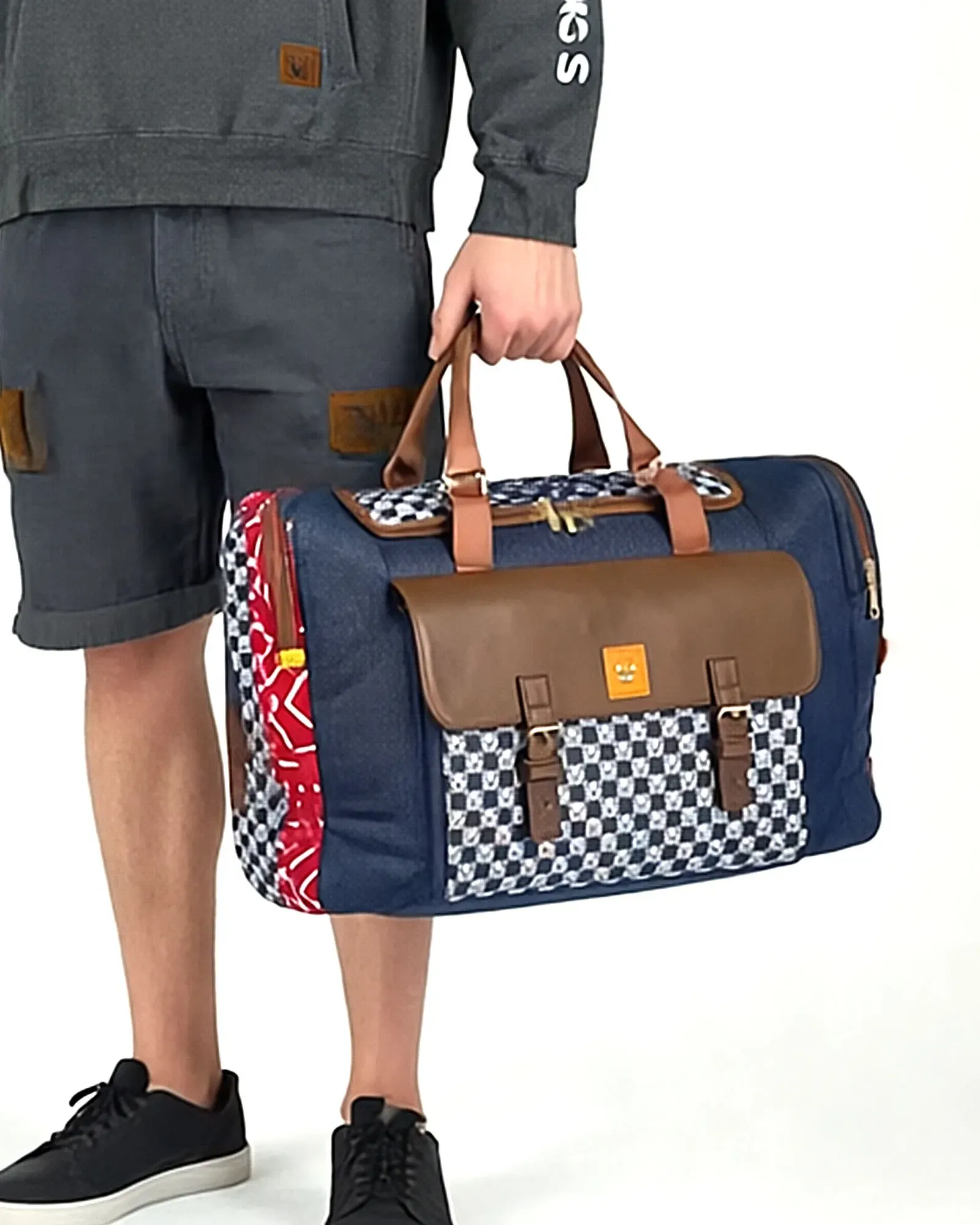 Man carrying the Traveller holdall in blue check fabric with brown leather