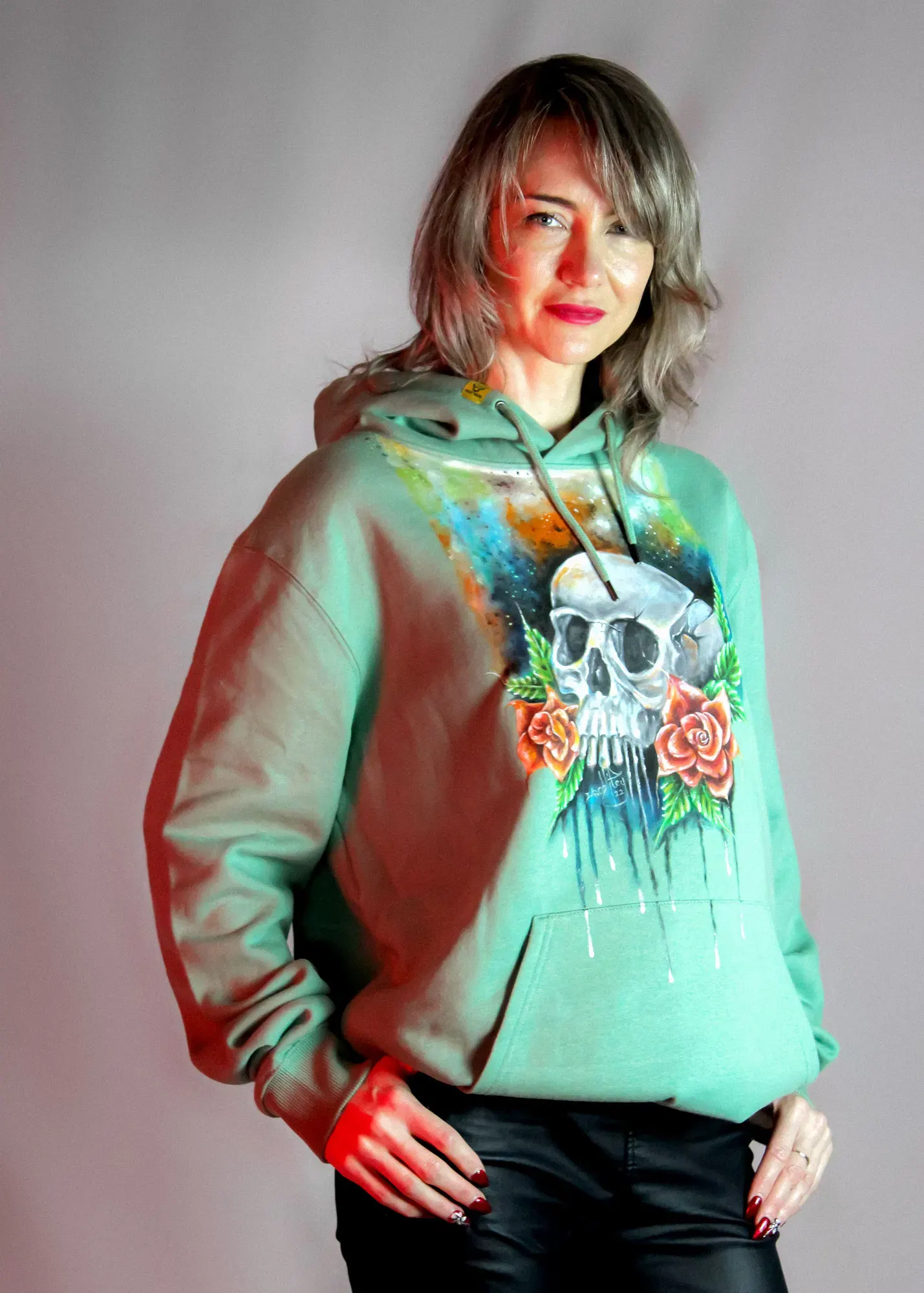 Woman wearing a hand-painted sage skull hoodie